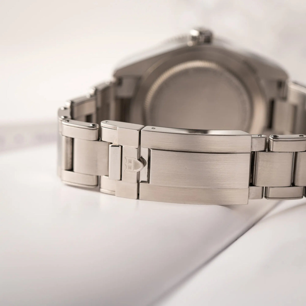 Detailaufnahme der geschlossenen Schliesse von der Tudor BlackBay GMT Coke der Referenz 7939G1A0NRU mit der schwarz-roten Lünette und bronzefarbenen Details am Edelstahlarmband 