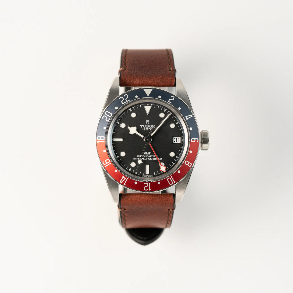Frontale Ansicht der Tudor Black Bay Pepsi mit der Referenz 97830RB am braunen Lederband im Neuzustand
