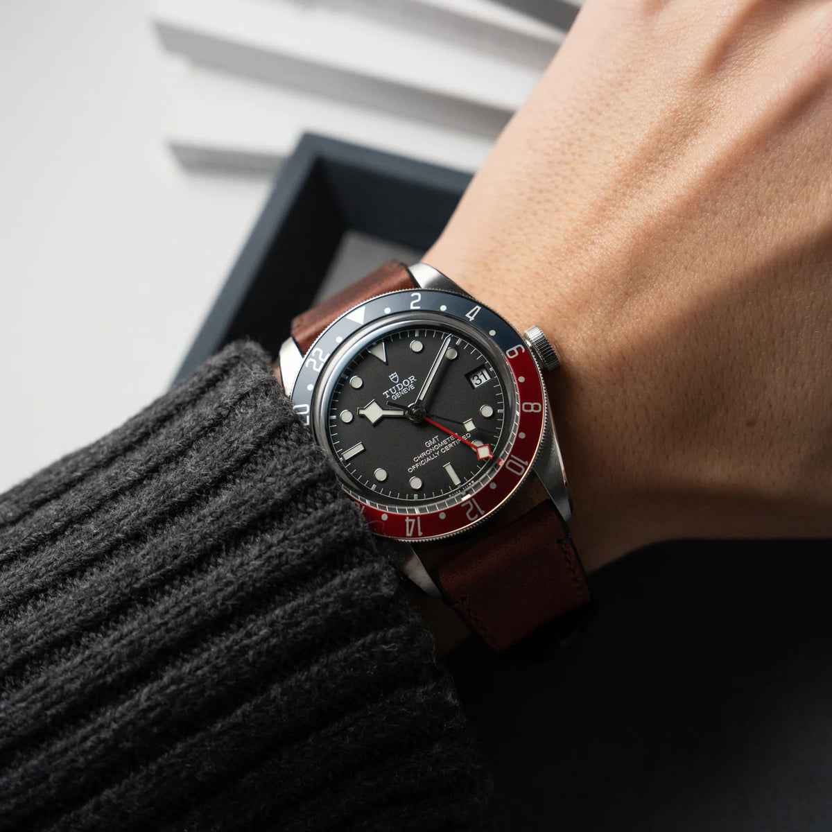 Wristshot mit der Tudor Black Bay Pepsi mit der Referenz 97830RB am braunen Lederband im Neuzustand