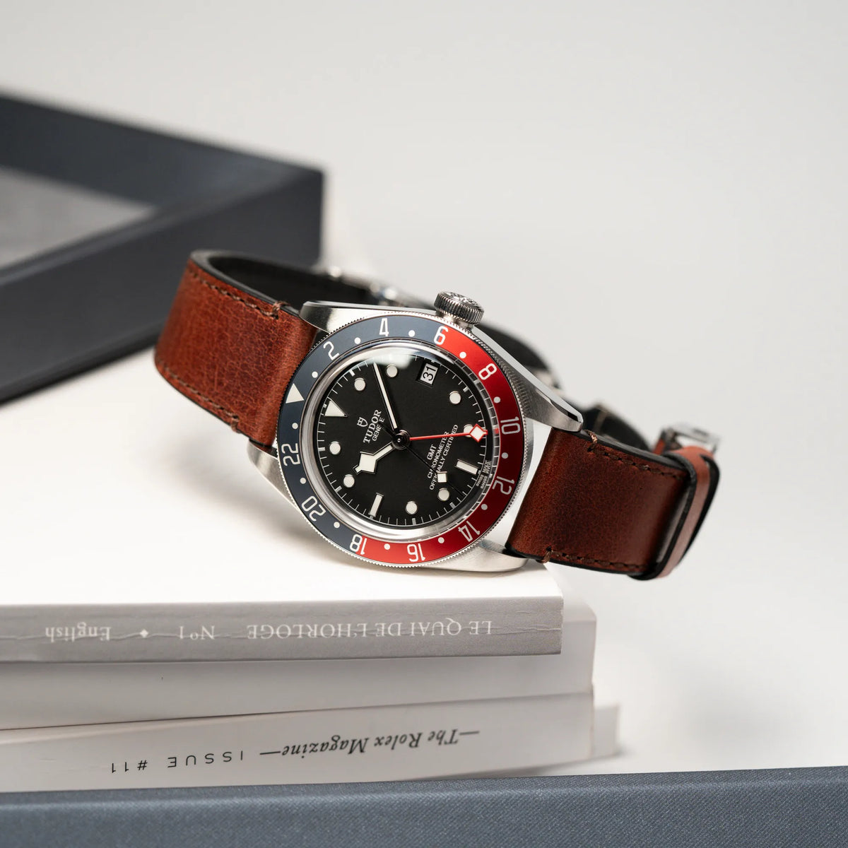 Produktfotografie der Tudor Black Bay Pepsi mit der Referenz 97830RB am braunen Lederband im Neuzustand