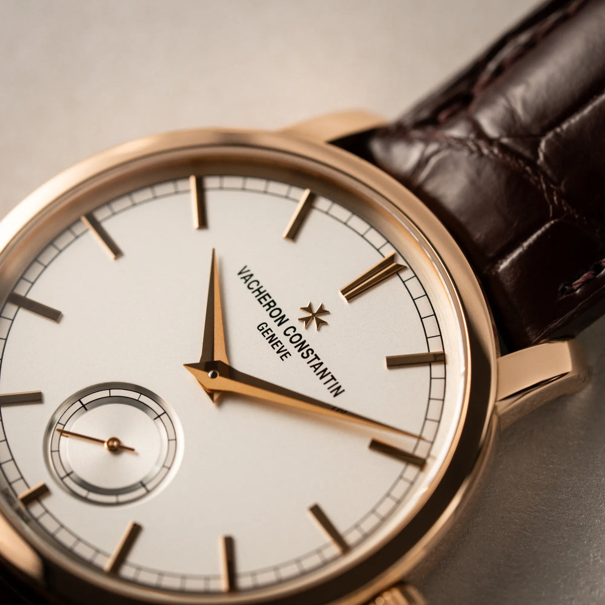 Makroaufnahme der Vacheron Constantin Patrimony 82172 in Roségold am braunem Lederband in einem nahezu neuwertigen Zustand zeigt den "Vacheron Constantin Geneve" Schriftzug auf dem weiß/silbernen Zifferblatt