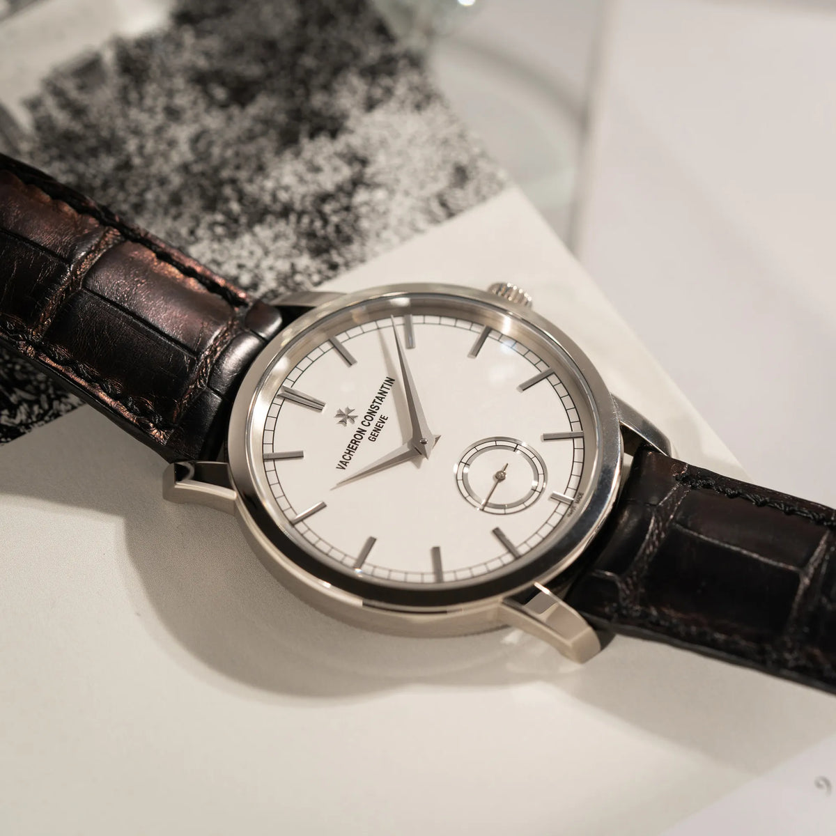 Produktfotografie mit Fokus auf dem Uhrenkpopf der Vacheron Constantin Traditionelle 82172 mit weißem Zifferblatt und einem Weißgold-Gehäuse am braunem Lederband