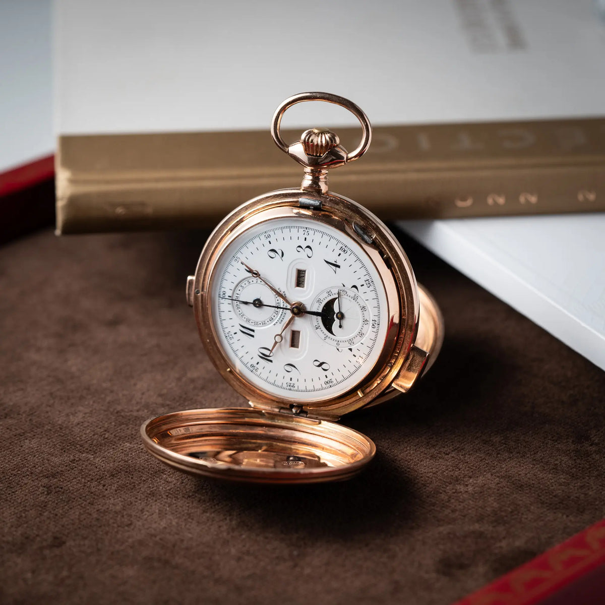Produktfotografie der Vollkalender Taschenuhr aus 14 Karat Roségold mit viertel Stunden Repetition und Mondphase-Anzeige bei 6 Uhr 