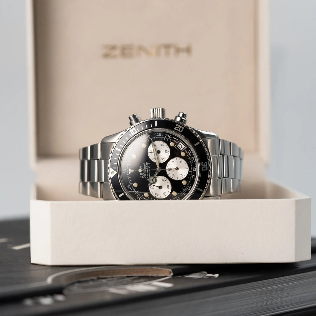 Produktfotografie des Zenith El Primero Chronograph aus 1993 mit schwarzem Zifferblatt und silbernen Totalisatoren in der Uhrenbox