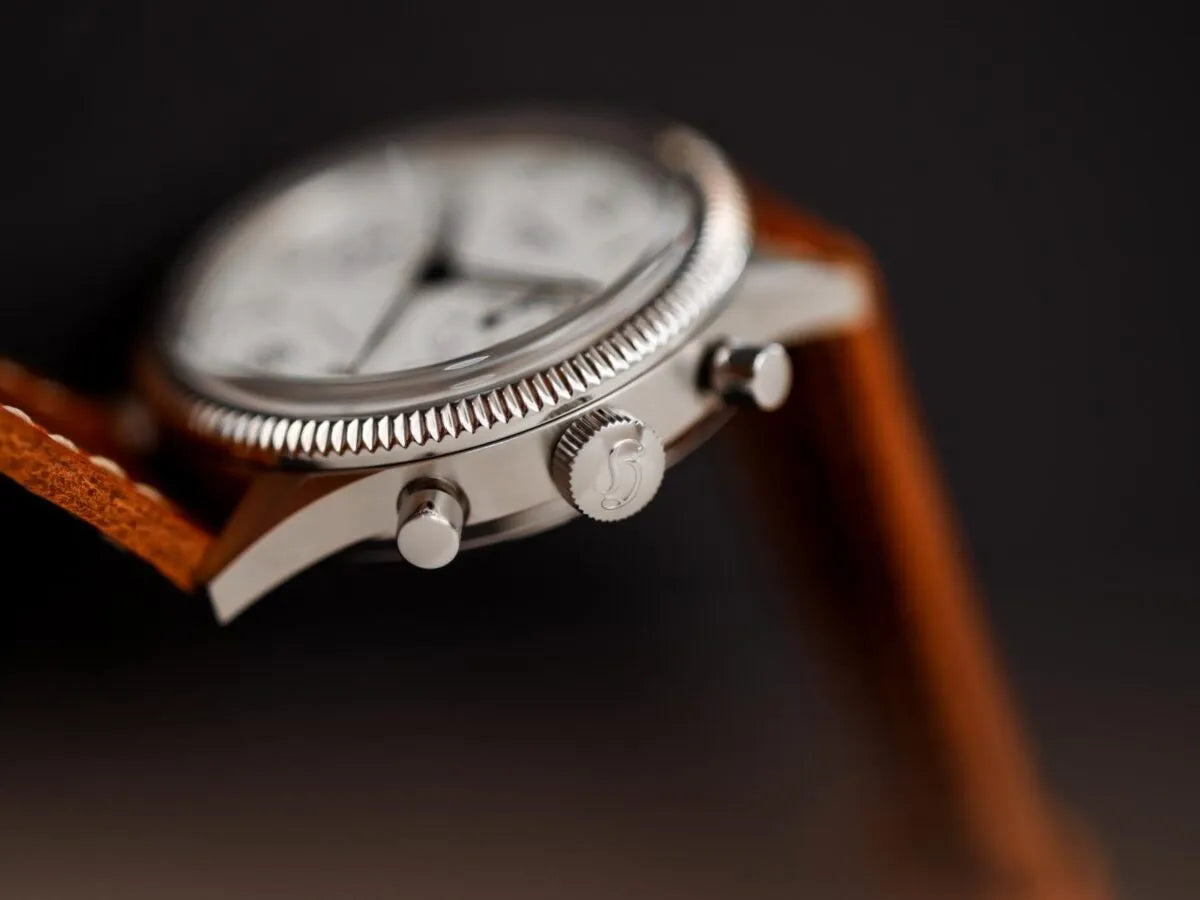 Produktfotografie zeigt die seitliche Gehäuseflanke mit Aufzugskrone und Chrono-Pushern der Hanhart 417 ES Moby Dick mit weißem Zifferblatt und gebläuten Zeigern im 39 mm-Gehäuse 