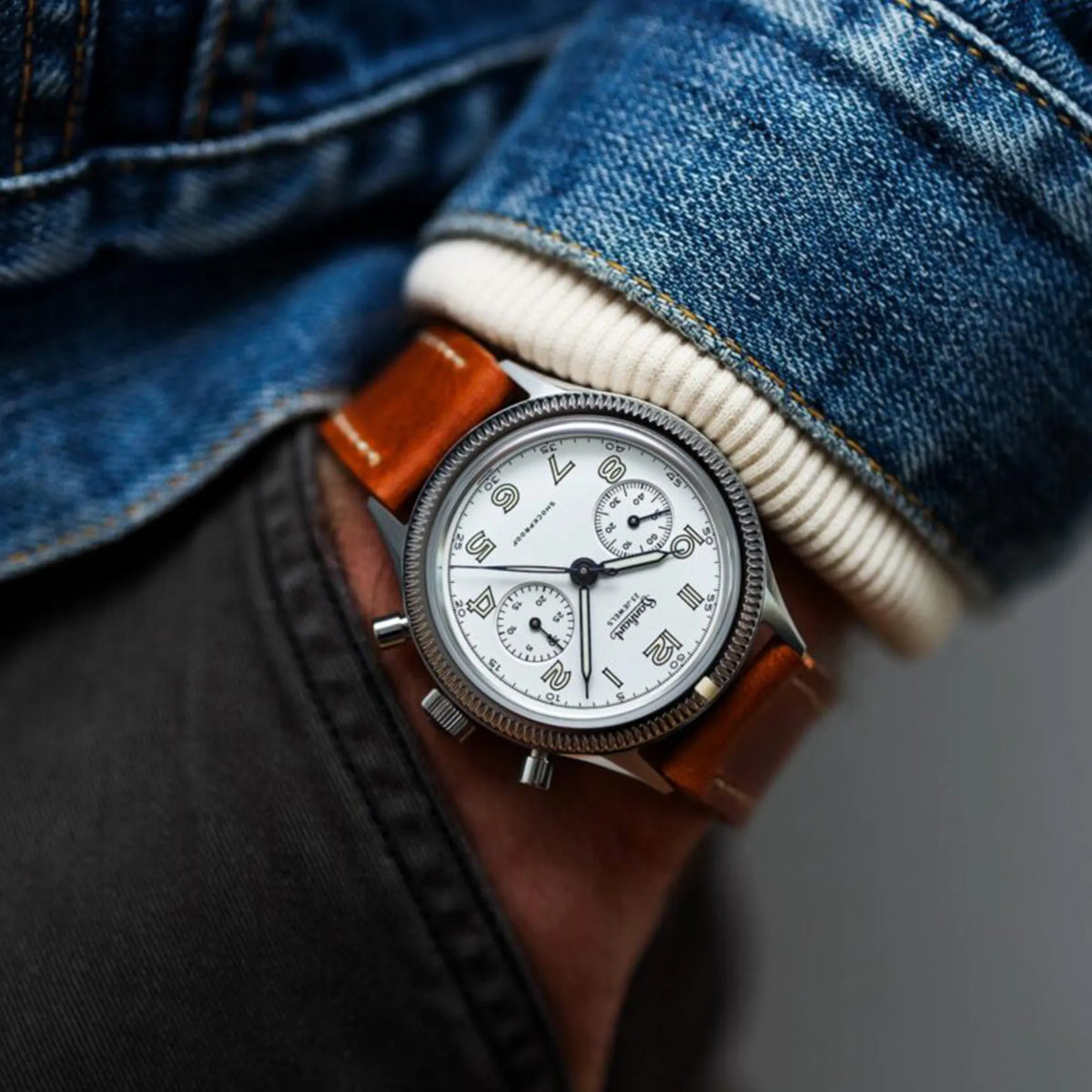 Mann trägt die Hanhart 417 ES Moby Dick mit weißem Zifferblatt und gebläuten Zeigern im 39 mm-Gehäuse am Edelstahlarmband an seinem Handgelenk